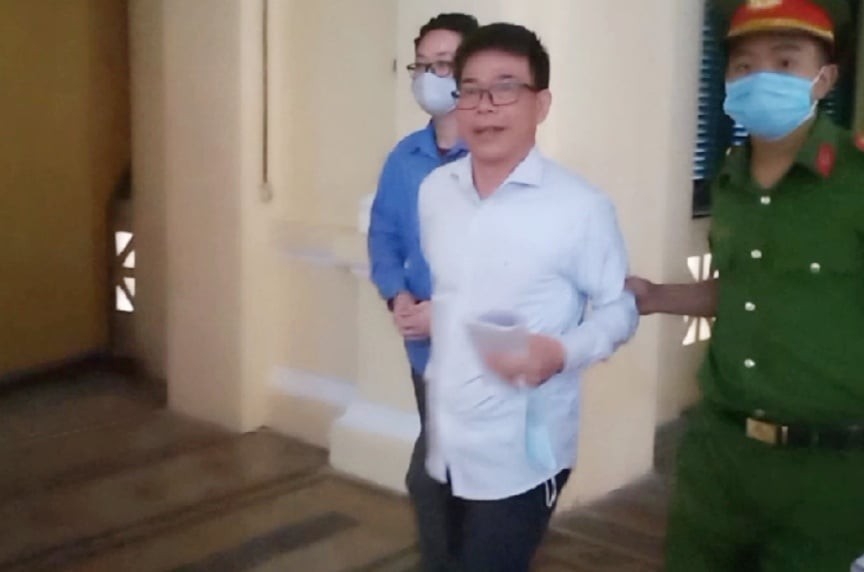 Cảnh sát dẫn giải cựu Phó Chánh án Nguyễn Hải Nam và giảng viên Lâm Hoàng Tùng vào phòng xử án. Ảnh: Tân Châu