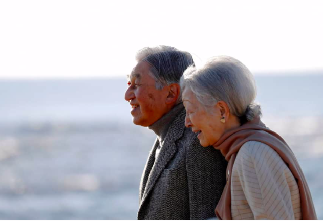 Nhà Vua Akihito và Hoàng hậu Michiko trong một cuộc đi dạo trên bãi biển. (Ảnh: Kyodo)
