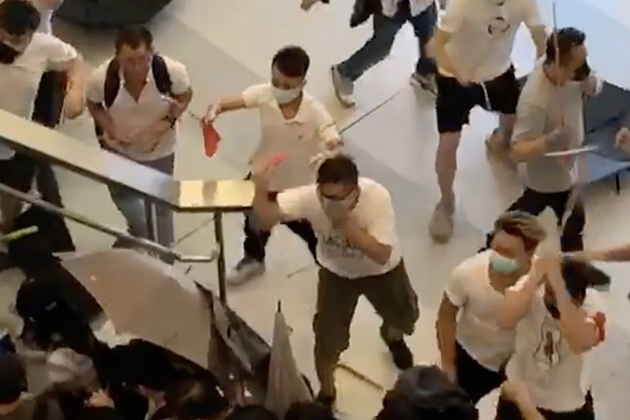 Đám người mặc áo trắng tấn công người dân Hong Kong ở ga tàu điện ngầm lúc đêm muộn. (Ảnh chụp từ clip)
