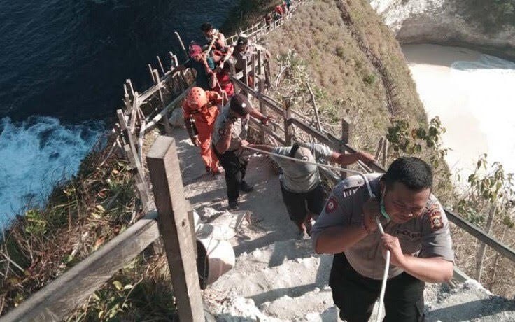 Thi thể du khách người Việt được lực lượng cứu hộ đưa lên từ vách đá. (Ảnh: Nusabali.com)