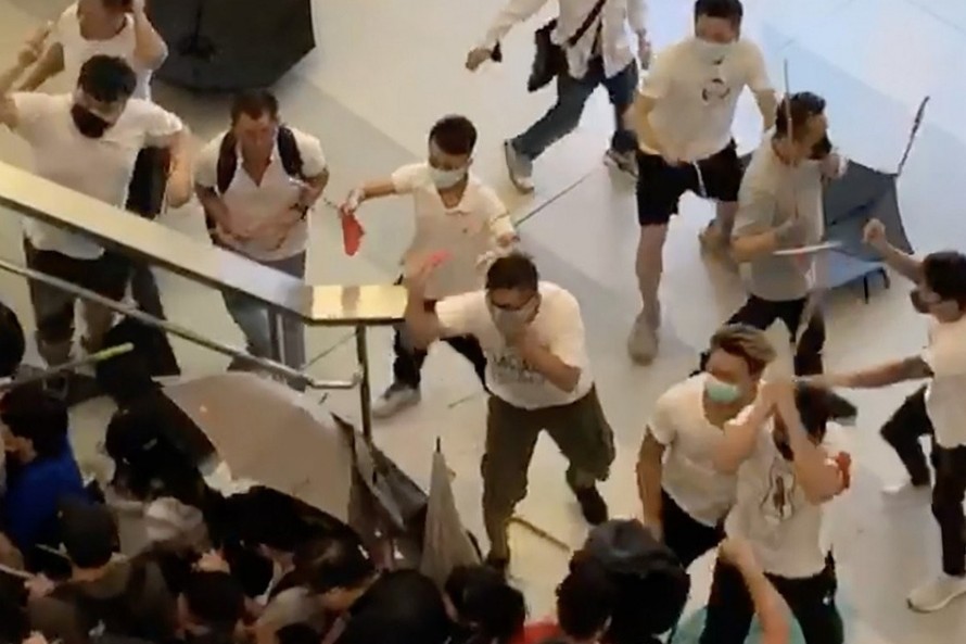 Nhóm côn đồ mặc áo trắng dùng gậy sắt tấn công người dân Hong Kong tại một ga tàu điện ngầm vào cuối tuần trước. (Ảnh: SCMP)