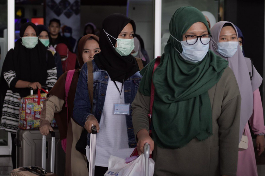 Hành khách đeo khẩu trang khi làm thủ tục tại sân bay Cengkareng ngày 1/2. (Ảnh: Getty Images)