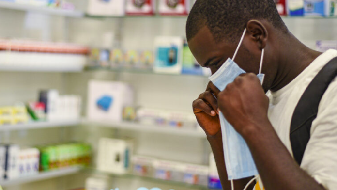 Một người thử đeo khẩu trang y tế tại hiệu thuốc ở Zambia. (Ảnh: AP)