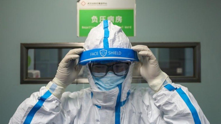 Một bác sĩ ở Vũ Hán mặc đồ bảo hộ trước khi bước vào ca làm việc. (Ảnh: CNN)