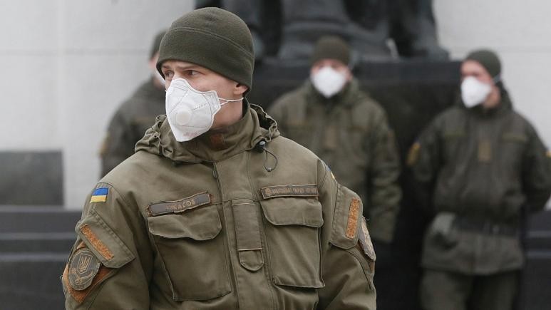Lực lượng vệ binh Ukraine đeo khẩu trang khi đứng làm nhiệm vụ trước tòa nhà quốc hội ở Kiev. (Ảnh: AP)