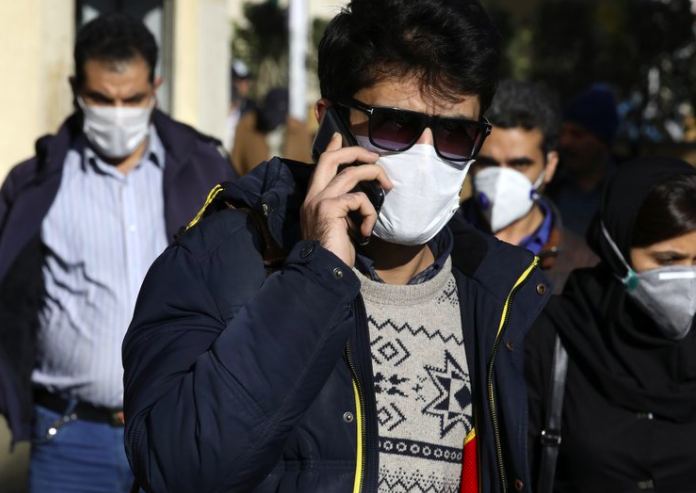 Một người đeo khẩu trang khi đang nói chuyện điện thoại ở khu trung tâm Tehran ngày 2/3. (Ảnh: AP)