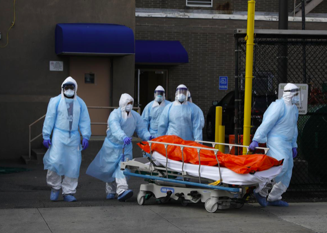 Các nhân viên chuyển một thi thể bệnh nhân chết vì COVID-19 từ bệnh viện ở Brooklyn, New York, ngày 2/4. (Ảnh: Reuters)
