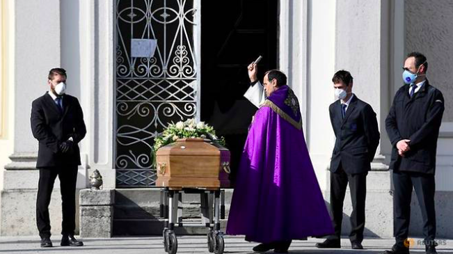 Một linh mục làm lễ cho bệnh nhân chết vì COVID-19 ở Siriate ngày 28/3. (Ảnh: Reuters)