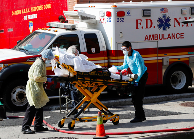  Một bệnh nhân được vận chuyển từ Trung tâm bệnh viện Elmhurst, Mỹ, ra xe cứu thương ngày 7/4. (Ảnh: AP) 