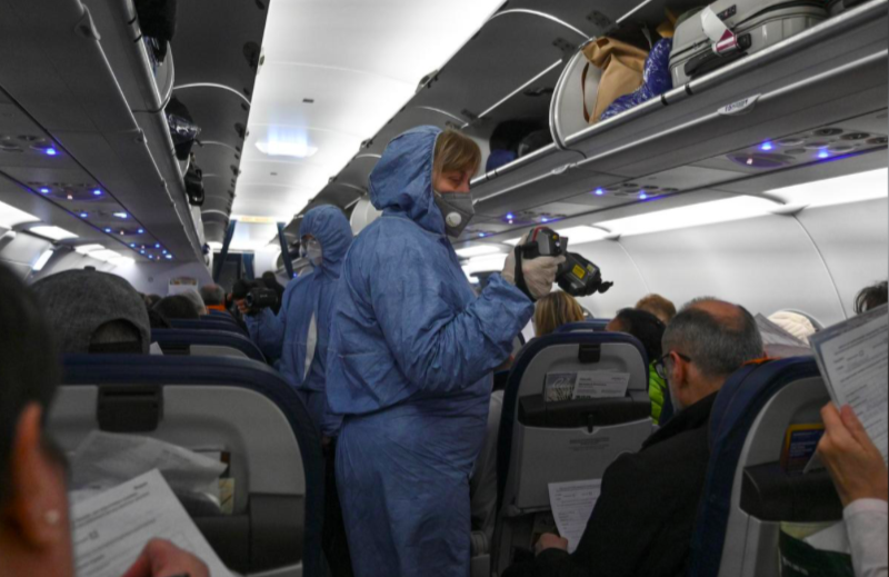 Nhân viên y tế kiểm tra sức khoẻ hành khách trên một chuyến bay từ khu vực gần Mátxcơva ngày 17/3. (Ảnh: Reuters)