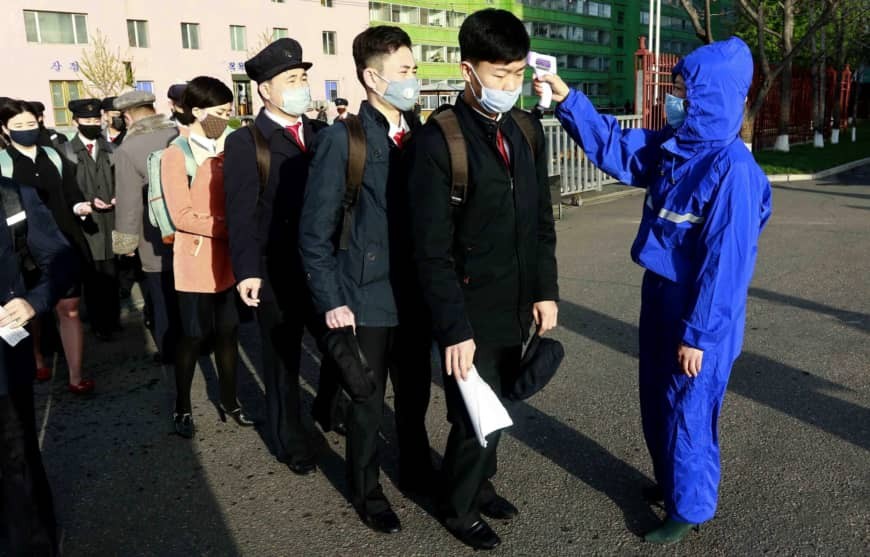 Sinh viên một trường đại học ở Bình Nhưỡng được kiểm tra thân nhiệt khi đến trường hôm 22/4. (Ảnh: AP)
