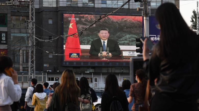 Màn hình TV ở Bắc Kinh chiếu hình ảnh ông Tập Cận Bình phát biểu tại cuộc họp của Đại hội đồng Y tê thế giới. (Ảnh: CNN)