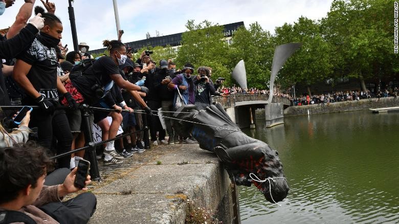 Người biểu tình ở London vứt tượng Edward Colston xuống sông. (Ảnh: CNN)