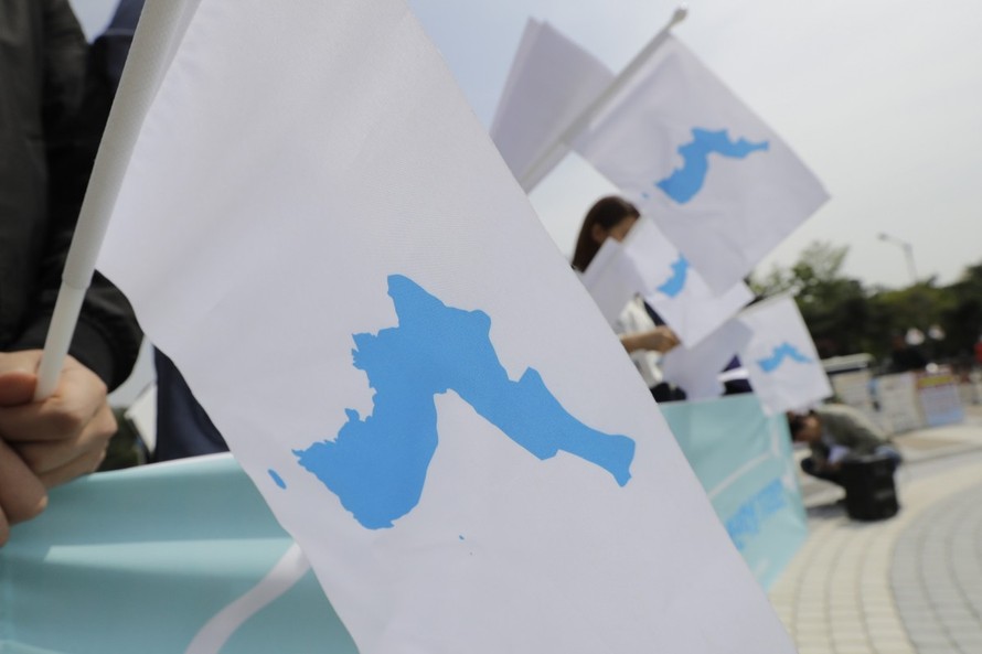 Người Hàn Quốc cầm cờ với hình ảnh bán đảo thống nhất trong dịp hội nghị thượng đỉnh liên Triều năm 2018. (Ảnh: AP)