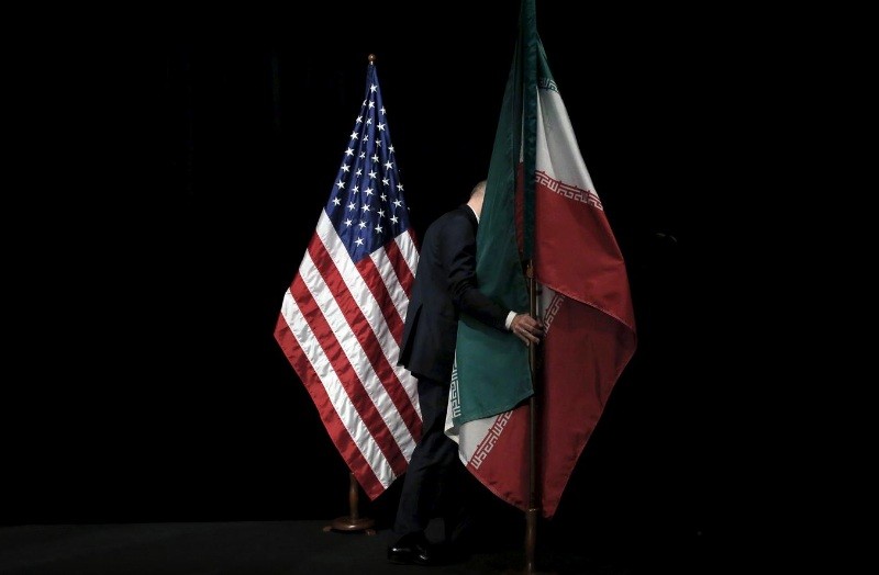 Cờ Mỹ và Iran được chuyển đi sau phần chụp ảnh chung trong cuộc đàm phán về thỏa thuận hạt nhân Iran tại Vienna năm 2015. (Ảnh: Reuters)