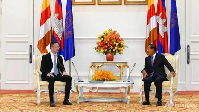 Thủ tướng Campuchia Hun Sen (phải) không đeo khẩu trang khi tiếp Ngoại trưởng Hungary. (Ảnh: AP)