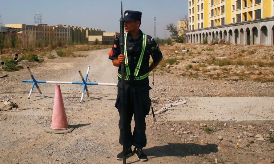 Một nhân viên an ninh đứng gác trước cơ sở mà Trung Quốc nói là dùng để đào tạo nghề cho người dân Tân Cương. (Ảnh: Reuters)