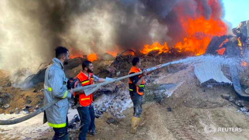 Lực lượng cứu hoả Palestine dập đám cháy ở một kho sơn bị Israel tấn công. (Ảnh: Reuters)