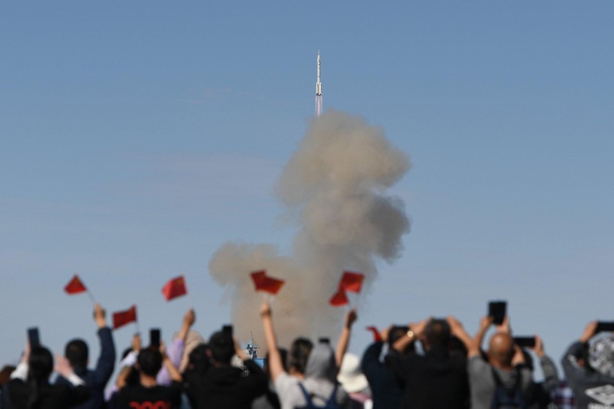 Nhiều người hò reo khi tên lửa bắt đầu hành trình đưa các phi hành gia Trung Quốc vào trạm vũ trụ. (Ảnh: Xinhua)