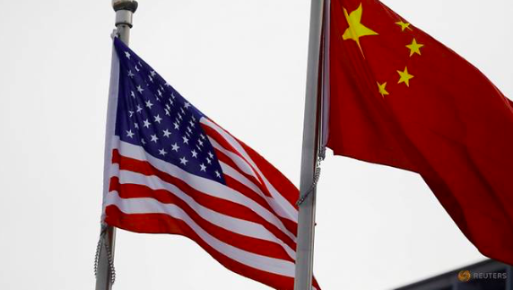 Quốc kỳ của Mỹ và Trung Quốc bên ngoài một công ty ở Bắc Kinh. (Ảnh: Reuters)