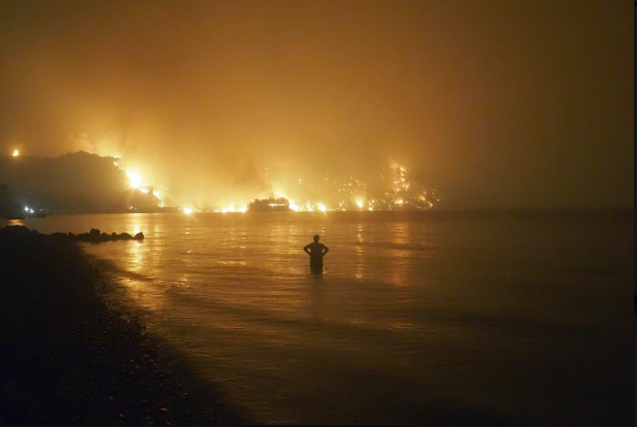 Một người đàn ông đang đứng nhìn đám cháy rừng nghiêm trọng ở Hy Lạp. (Ảnh: AP)