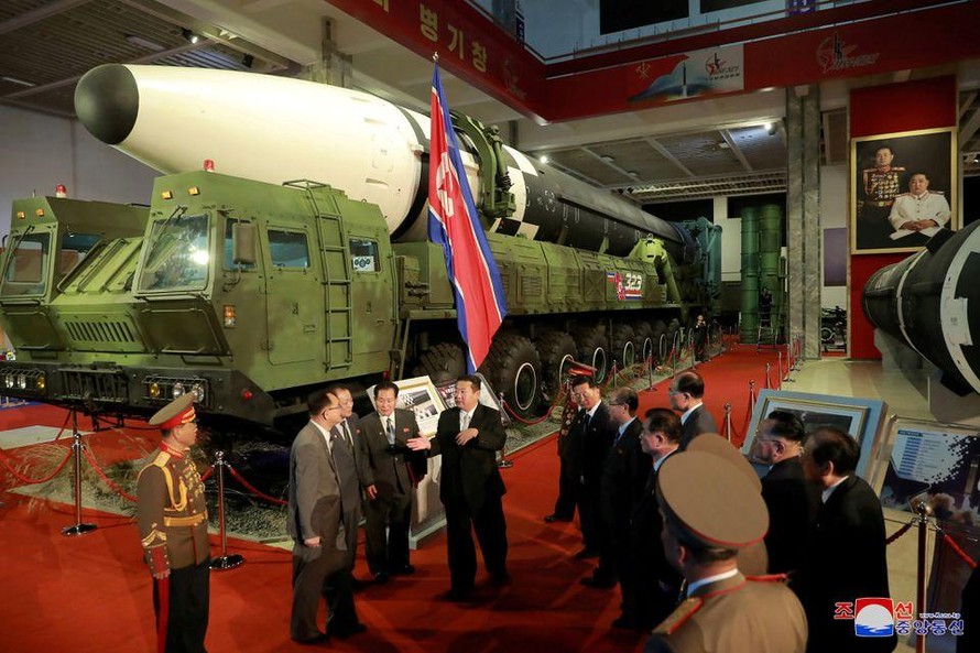 Chủ tịch Triều Tiên Kim Jong Un phát biểu với một số quan chức khi đứng cạnh các vũ khí được đưa ra triển lãm hôm 12/10. (Ảnh: KCNA)