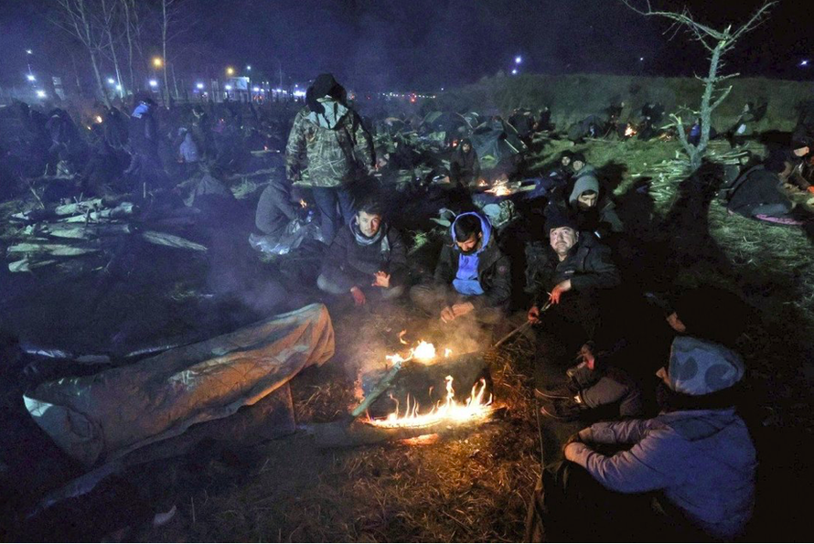 Những người di cư đốt lửa sưởi ấm khi mắc kẹt ở biên giới Belarus - Ba Lan. (Ảnh: AP)