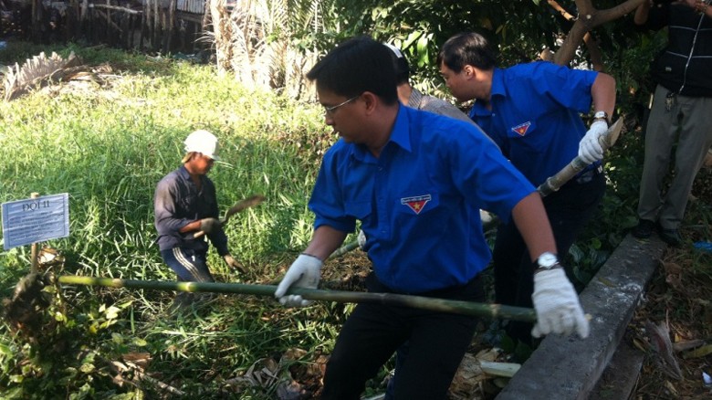 Anh Nguyễn Mạnh Cường, Bí thư Thành đoàn (phía trước) và anh Lê Quốc Phong, Bí thư Trung ương Đoàn (phía sau), đang làm vệ sinh môi trường mở đầu cho "Tháng thanh niên 2014".