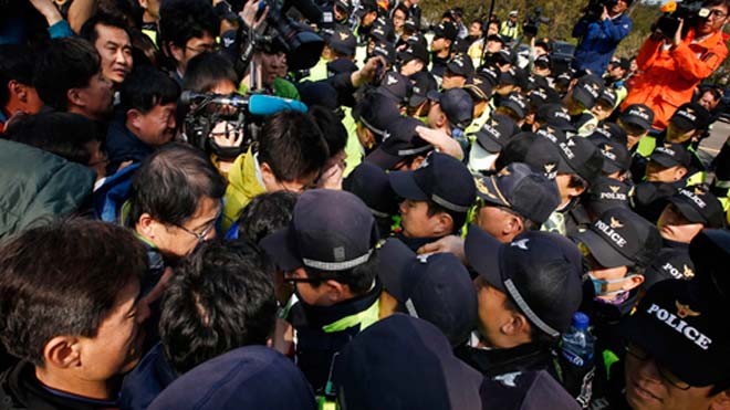 Người nhà của nạn nhân mất tích ẩu đả với cảnh sát để đòi qua cầu về Seoul. Ảnh: Reuters.