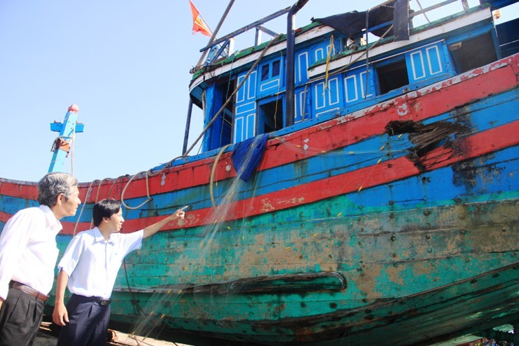 Ông Ngữ và cán bộ huyện đảo Hoàng Sa khảo sát hiện trạng hư hại con tàu đắm.