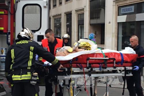Cảnh sát Pháp chuyển một nạn nhân bị thương trong vụ tấn công tòa soạn báo ở Paris làm 12 người chết. Ảnh: AFP- TTXVN.