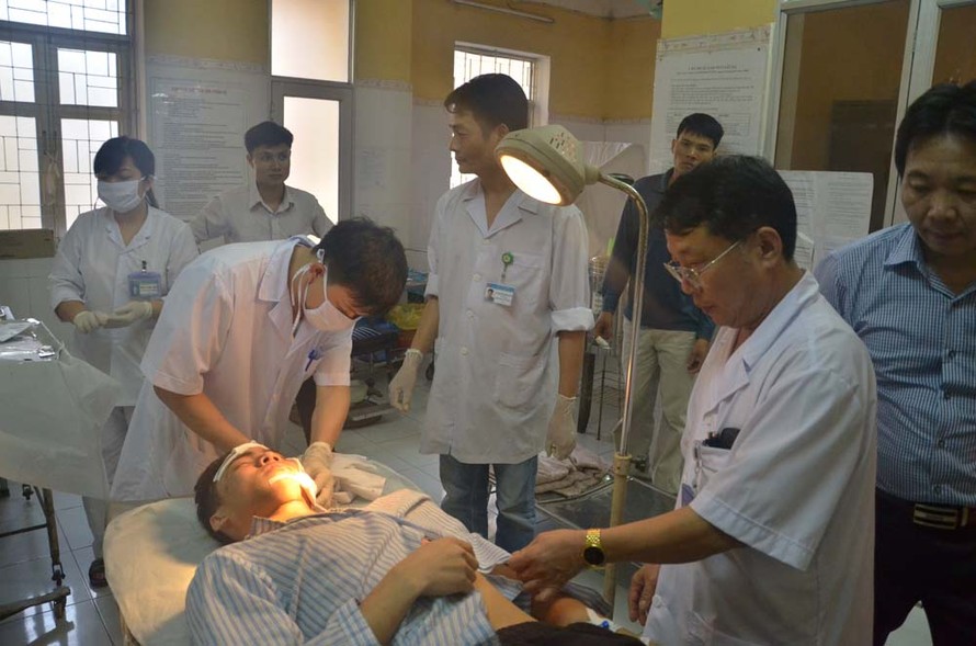 Các bác sĩ Bệnh viện Đa khoa Sơn Tây đang khâu vết thương cho nạn nhân Đỗ Bá Đồng. Ảnh: Thanh Hà.