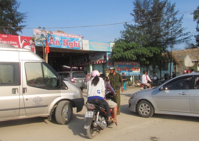 Lực lượng công an xã Hải Hoà vất vả phân làn xe vào khu du lịch.