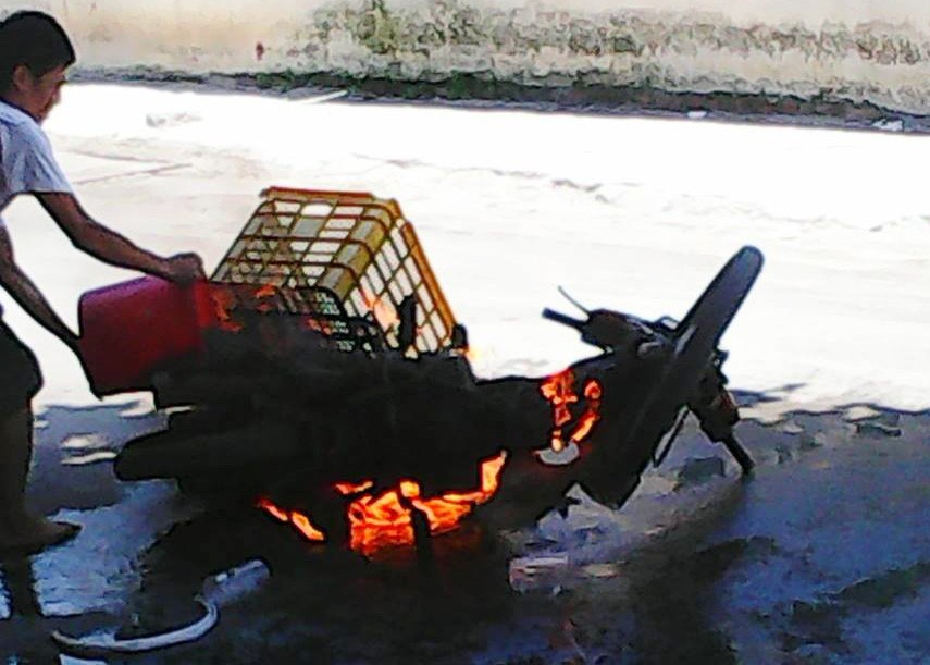 Chiếc xe bốc cháy ngùn ngụt trên đường được người dân dùng nước dập.