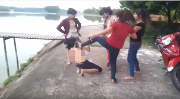 Hình ảnh nữ sinh bị lột đồ, bắt nhảy xuống hồ được cắt từ clip. Ảnh Internet.