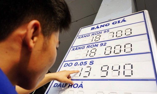 Giá bán lẻ xăng RON 92 được nhân viên cây xăng của Petrolimex trên phố Hào Nam (Hà Nội) điều chỉnh về 18.000 đồng một lít lúc 15h chiều nay. Ảnh: VnExpress