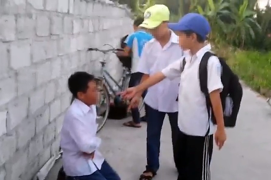 Nam học sinh bị bắt quỳ giữa đường và đánh hội đồng gây phẫn nộ. Ảnh cắt từ video.