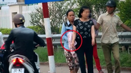 Một vụ dàn cảnh móc túi tại bến xe buýt trước bệnh viện Bạch Mai. Ảnh cắt từ video.