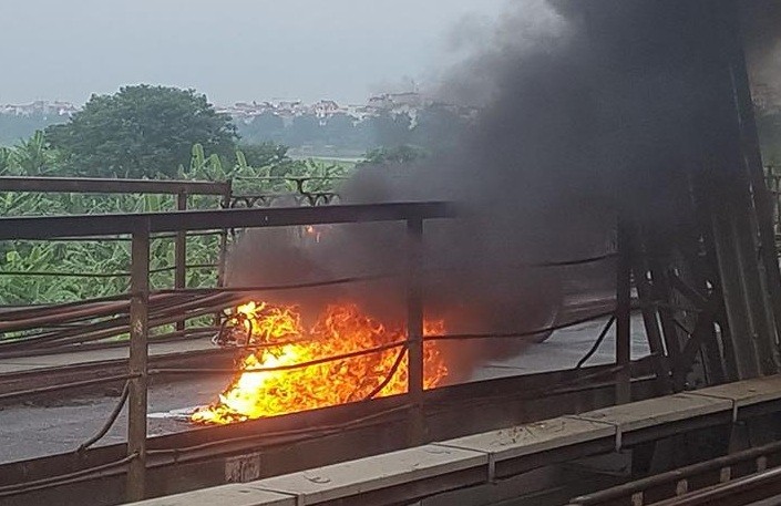 Chiếc xe máy bốc cháy ngùn ngụt giữa cầu Long Biên. Ảnh: CTV.
