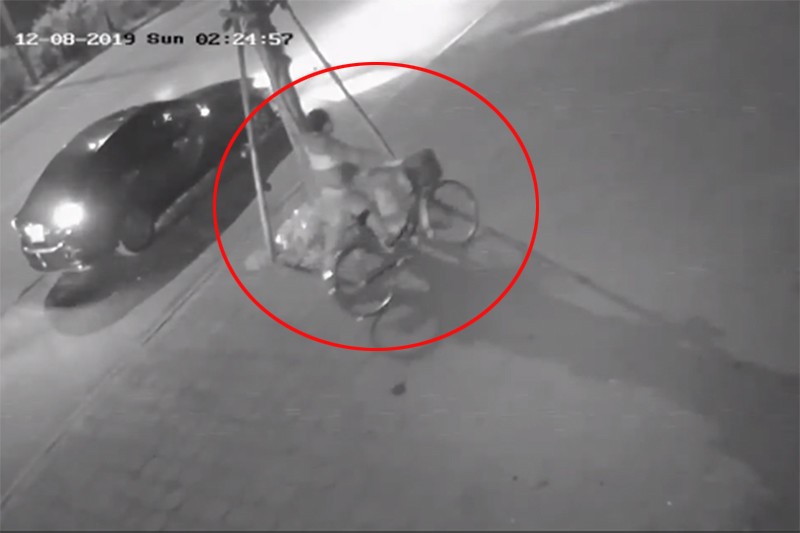 Hình ảnh được cho là người điều khiển ô tô gây tai nạn dắt chiếc xe đạp của nạn nhân xóa dấu vết. Ảnh cắt từ video.