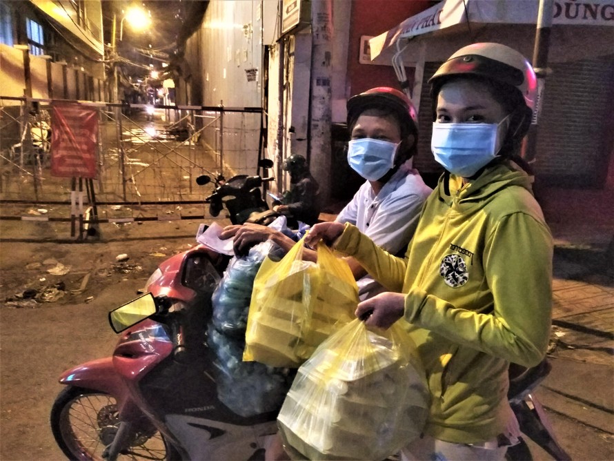 Vợ chồng chị Hương đi phát cơm từ thiện trong đêm tại phường Tân Thuận Đông đêm 20/7/2021
