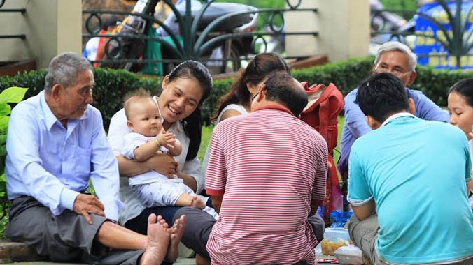 Cả gia đình bốn thế hệ cùng dùng bữa trưa ấm cúng và vui vẻ tại sân trường ĐH Khoa học Tự nhiên TPHCM. Trong ảnh, Kim Cúc (áo sơ mi trắng) cùng đứa cháu nhỏ vui đùa trong giờ nghỉ trưa.