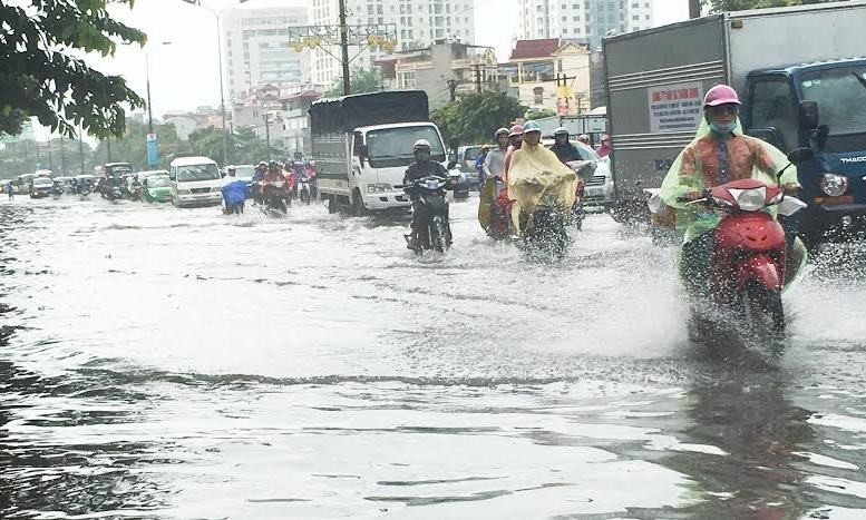 Mưa ngập hơn nửa bánh xe máy trên đường Giải Phóng sáng nay. Ảnh: T.Đảng.