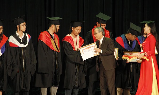 Anh hùng lao động, Nhà giáo Ưu tú Lê Công Cơ, Hiệu trưởng Trường ĐH Duy Tân trao bằng tốt nghiệp cho các sinh viên thủ khoa. Ảnh: Thanh Trần. 