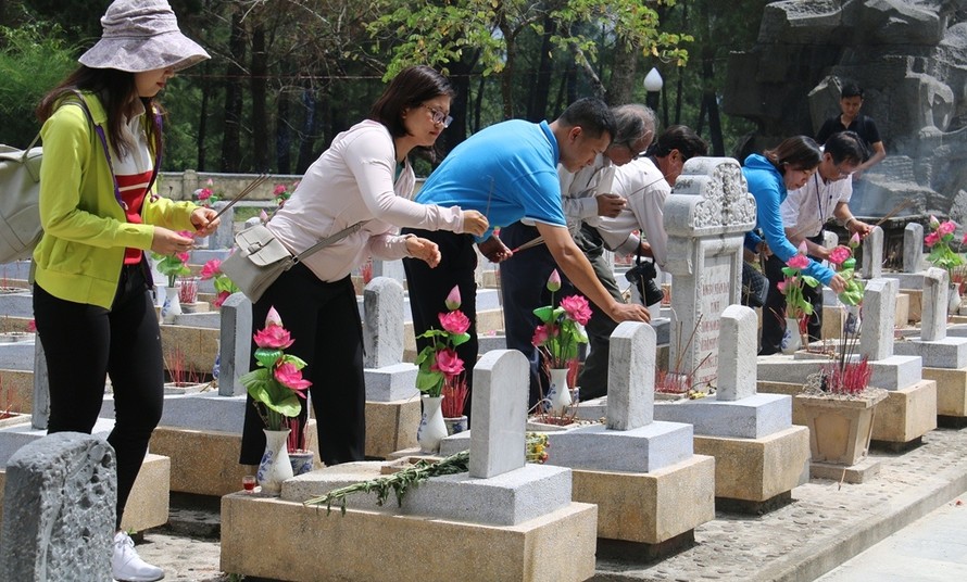 Các thành viên trong đoàn thắp hương tại phần mộ các liệt sĩ. 