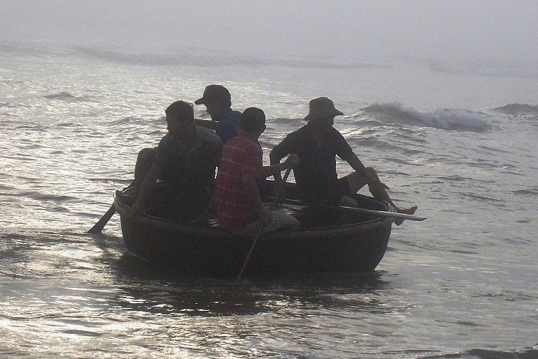 Ngư dân chèo thuyền đánh bắt trên biển.