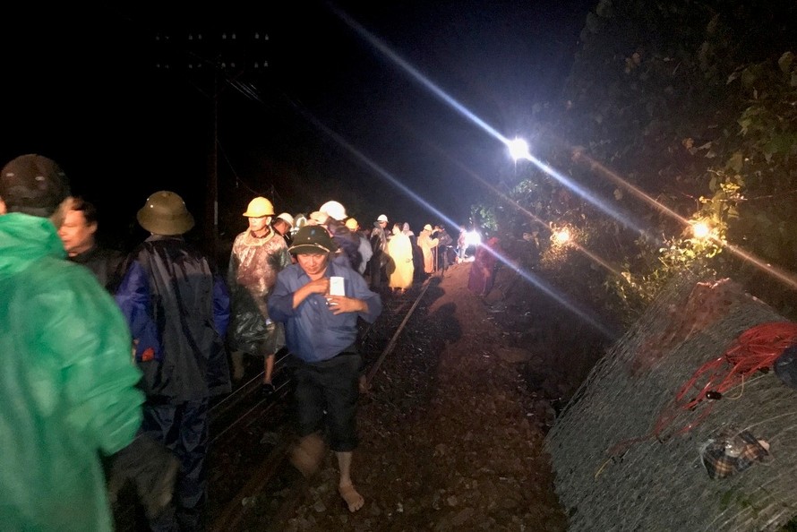 Lực lượng chức năng thực hiện công tác cứu hộ, xử lý sạt lở, bảo đảm an toàn cho hành khách đi tàu hỏa bị kẹt lại tại Lăng Cô do tắc đường.