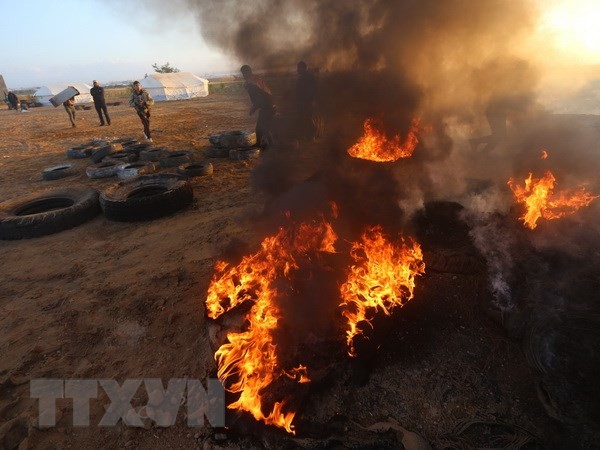 Người Palestine đốt lốp xe trong cuộc biểu tình tại khu vực biên giới Dải Gaza với Israel. (Nguồn: THX/TTXVN.)