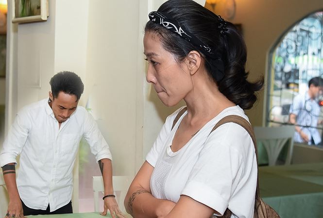 Vợ Phạm Anh Khoa đứng lặng lẽ trong buổi họp báo của chồng.