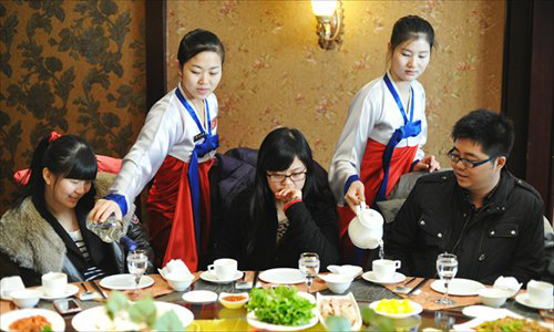 Các nữ bồi bàn phục vụ khách hàng Trung Quốc tại một nhà hàng Triều Tiên ở thành phố Trường Xuân, tỉnh Cát Lâm, Trung Quốc. Ảnh: Imagine China.